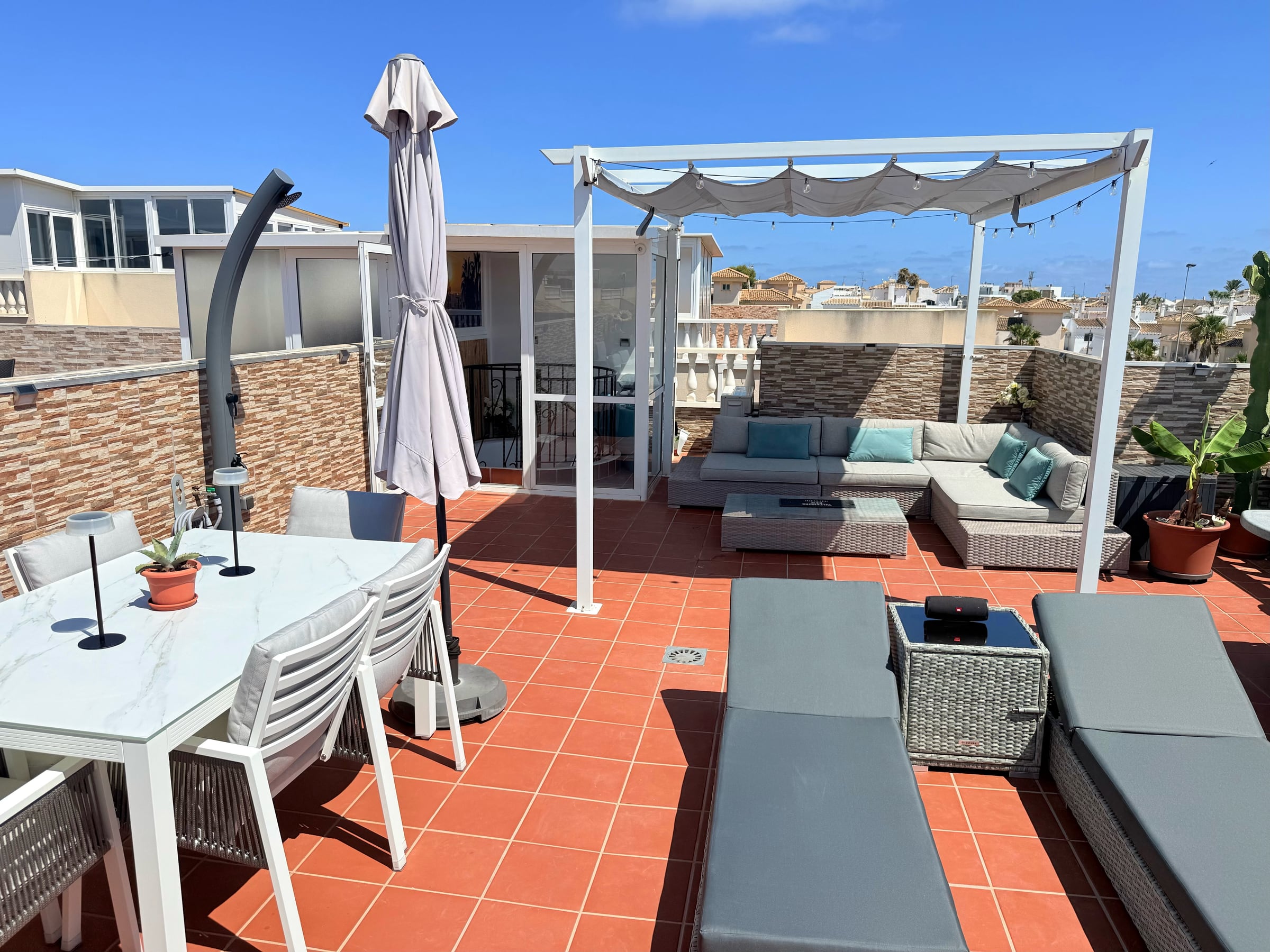 Casa de Holms stora takterrass med lounge, solstolar och matplats